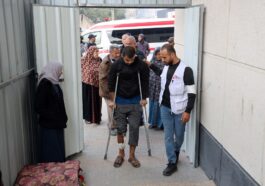 Profissional de MSF auxilia paciente com lesão na perna em uma clínica de cuidados pós-operatórios montada dentro do Hospital de Campanha Indonésio de Rafah, no sul de Gaza. Dezembro de 2023 (Foto: MSF)